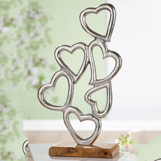 oro aluminium hearts piled on wood base sculpture in silver