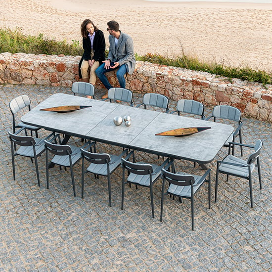 Photo of Rykon extending grey glass dining table with 12 armchairs